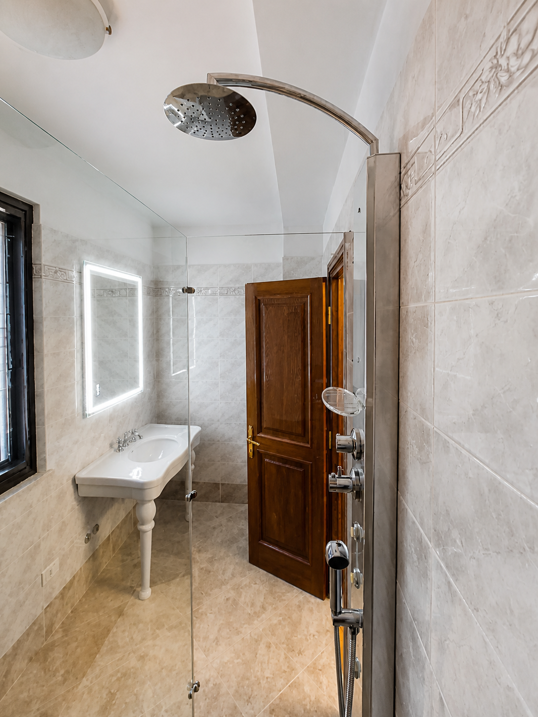 Bagno con box doccia in vetro e soffione a pioggia