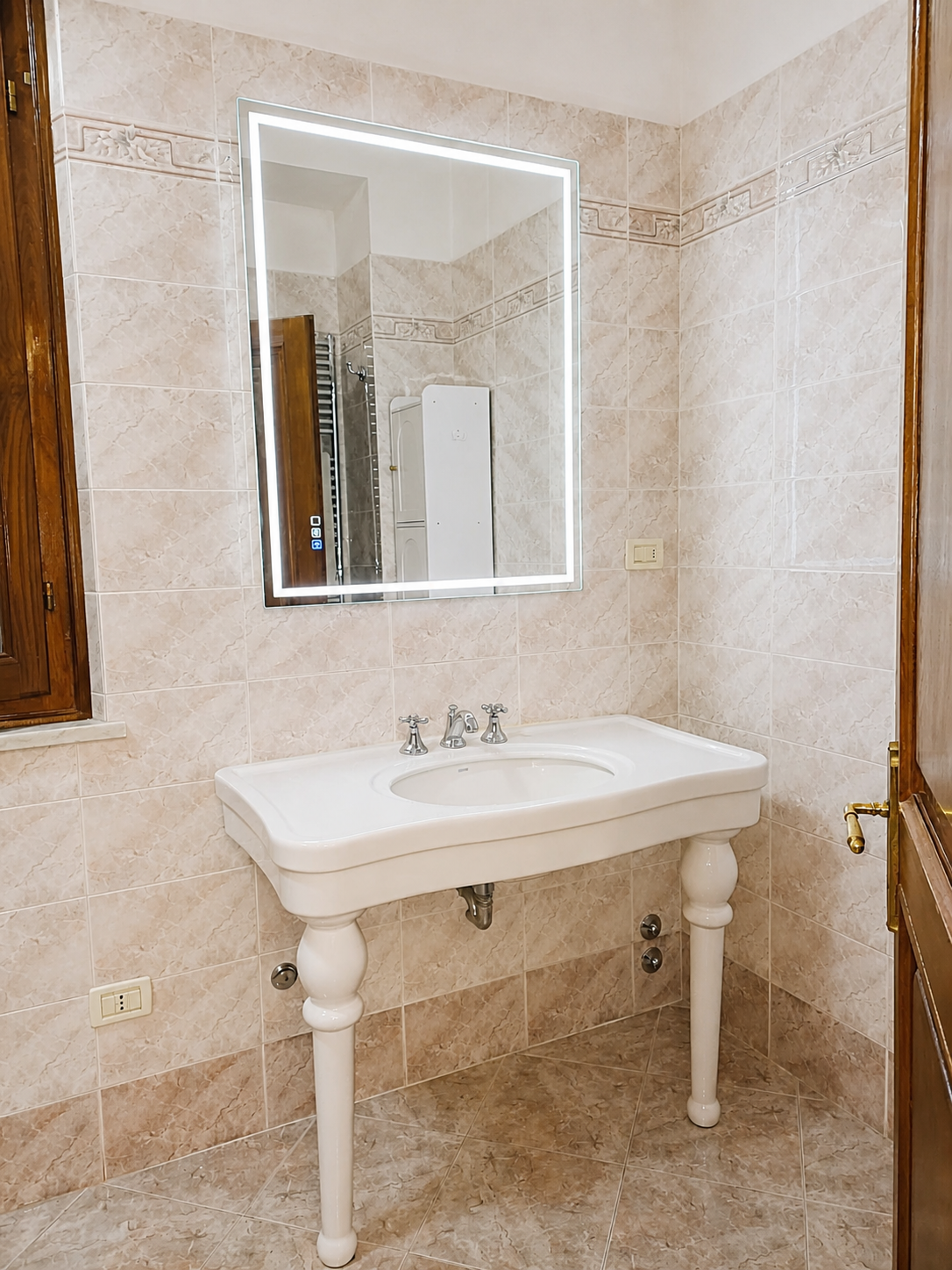 Bagno con lavabo e specchiera illuminata