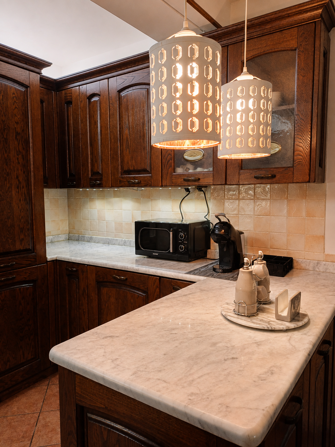 Cucina con bancone in marmo bianco e lampade a sospensione